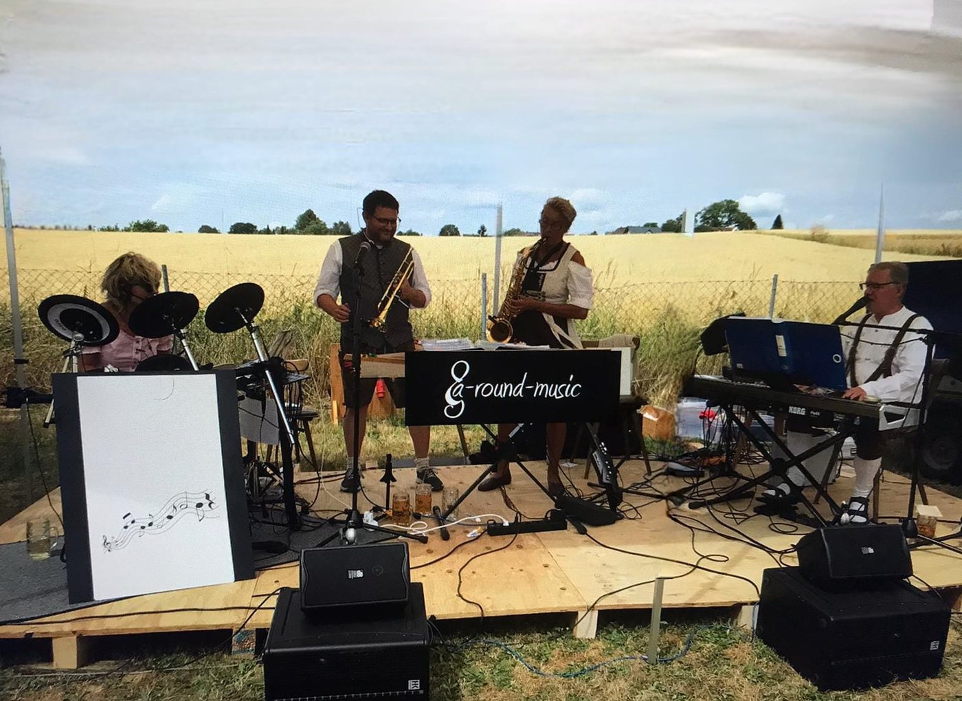 a-round-music live auf der Holzbühne vor dem reifen Kornfeld
